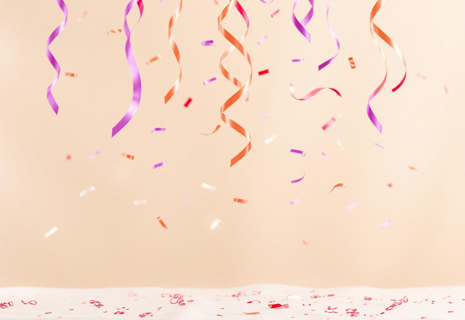 Confetes e fitas em tom roxo, rosa e laranja